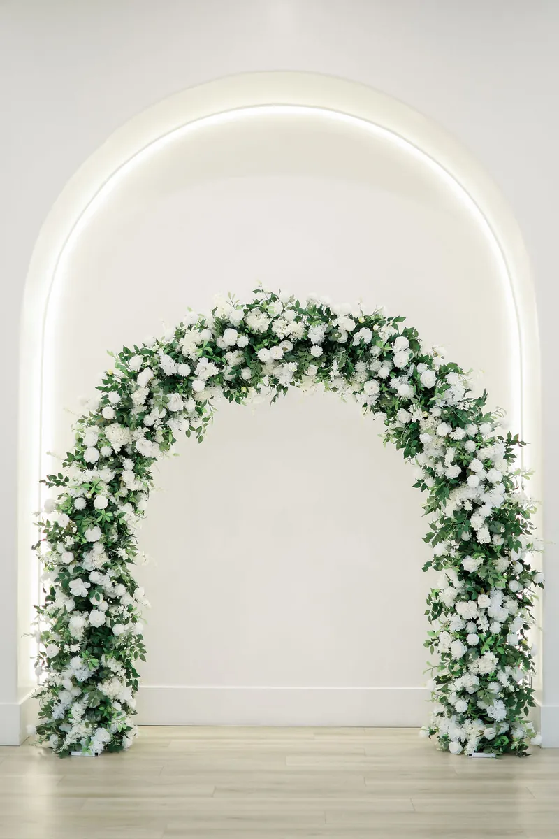 White floral arch in the ceremony space at Moments on Main, Payson