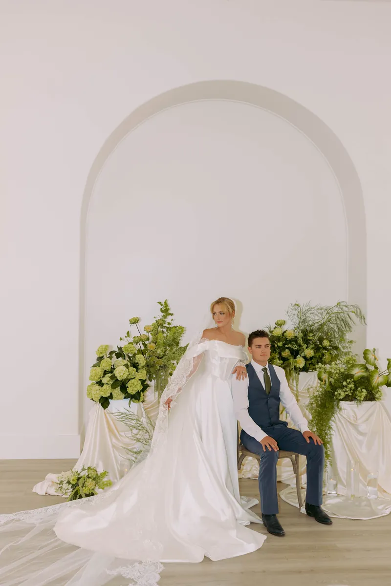 Bride and groom seated among florals inside Moments on Main, Payson