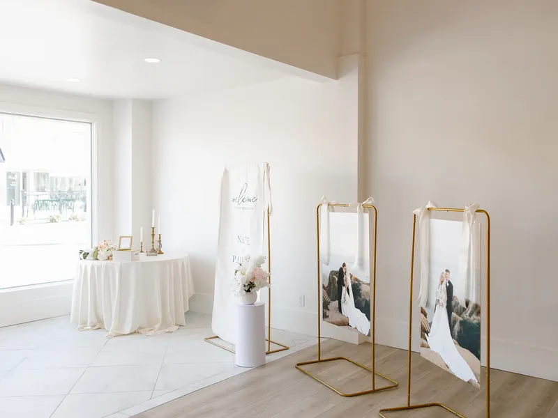 Sign-in table with framed photos by the front windows at Moments on Main