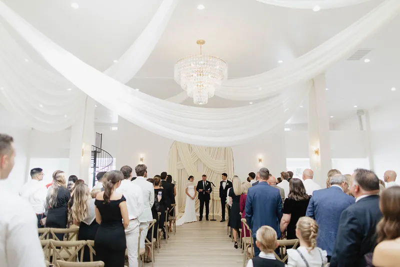 Wedding ceremony with seated guests in the main room at Moments on Main, Payson