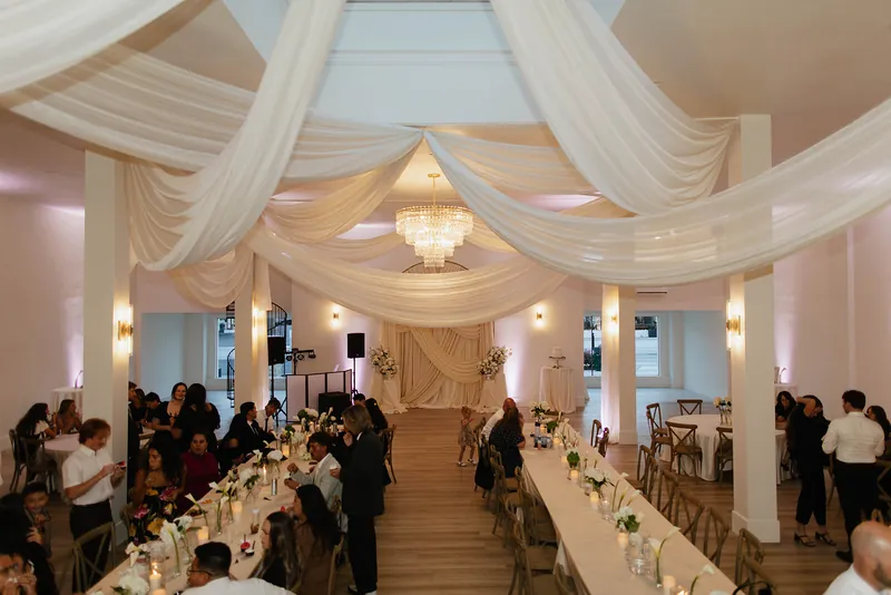 Wedding reception dinner at long tables under the draping at Moments on Main, Payson, Utah