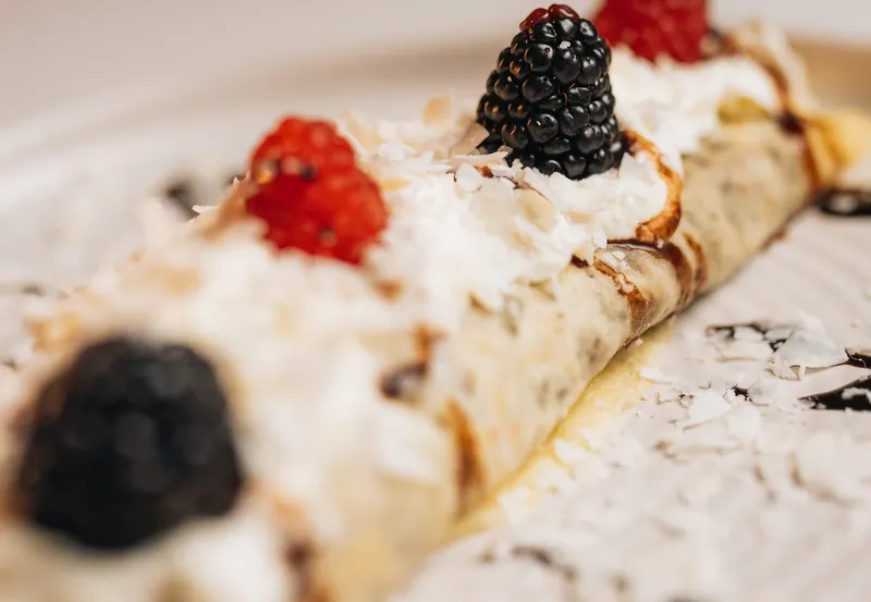 A crepe plated with berries, cream and coconut at a Moments on Main event, Payson, Utah