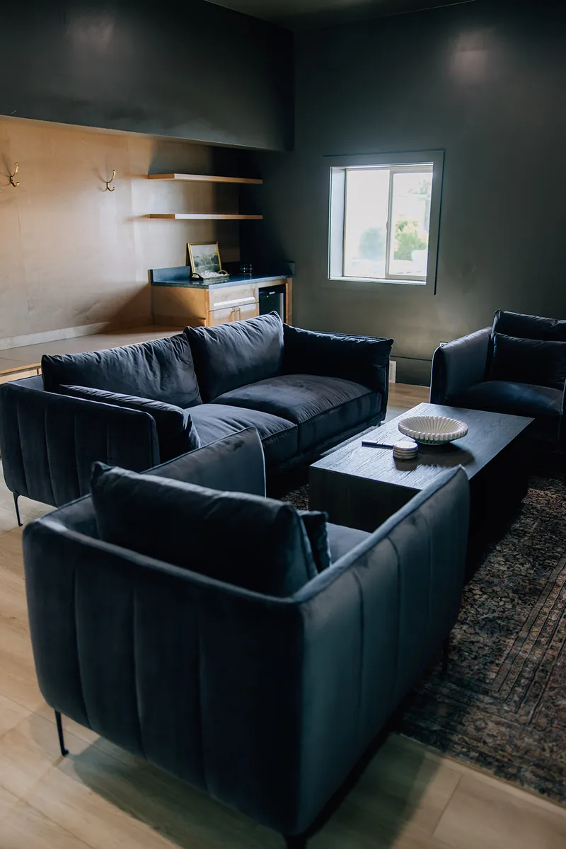 Groom's lounge with dark velvet sofas at Moments on Main, Payson, Utah