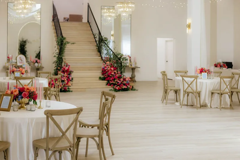 Reception room with round tables and the staircase at Moments on Main, Payson