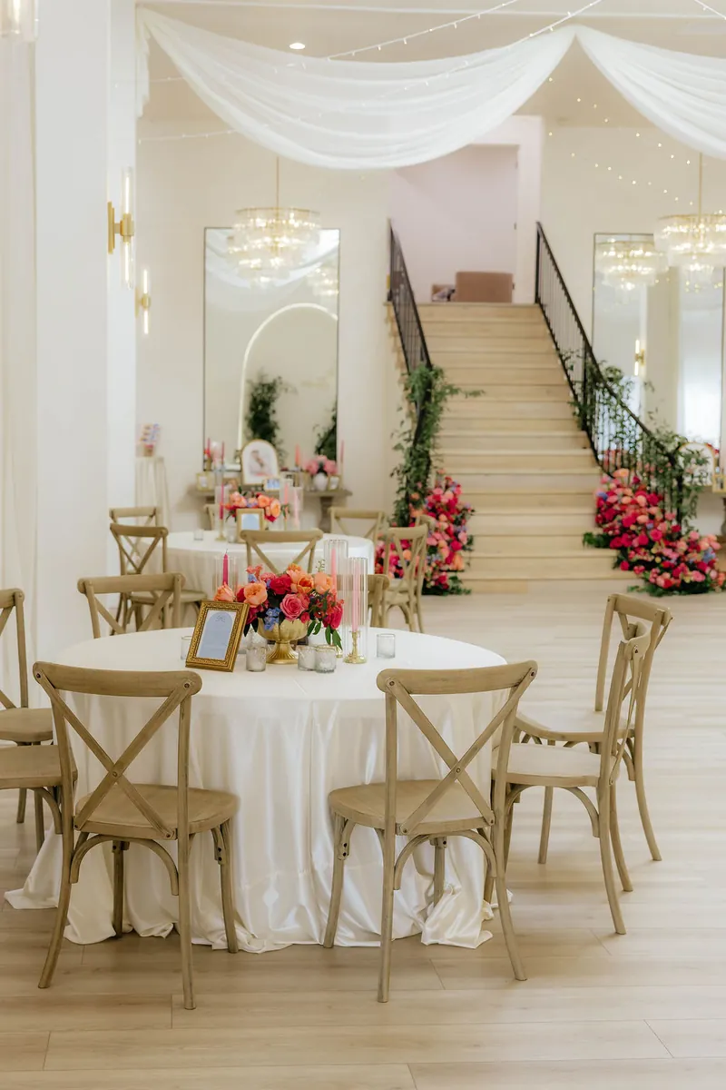 Round tables with bright florals beneath the staircase at Moments on Main, Payson