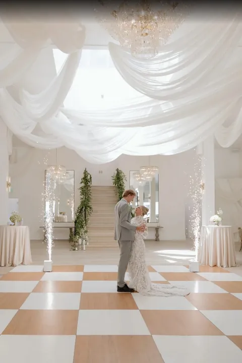 Couple on the checkered dance floor under the ceiling draping at Moments on Main, from Madison Prince's Google review