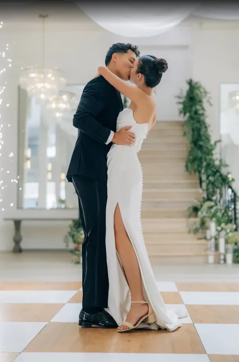 Couple kissing on the checkered floor beside the staircase at Moments on Main, from Jackie Siggard's Google review