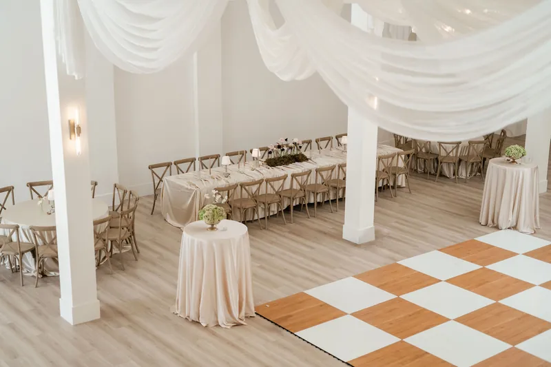 Long banquet tables and round cocktail tables set beside the checkered dance floor
